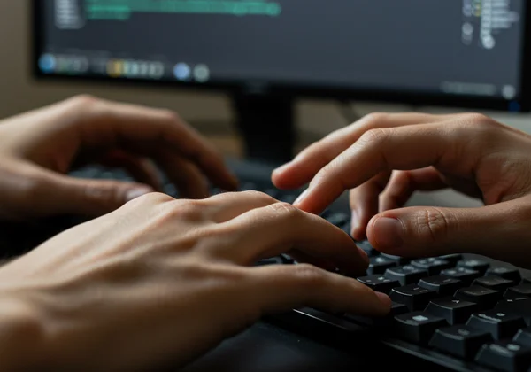 Hands on keyboard practicing typing exercises.